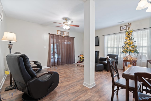 living room with ceiling fan, wood-type flooring, and ornate columns