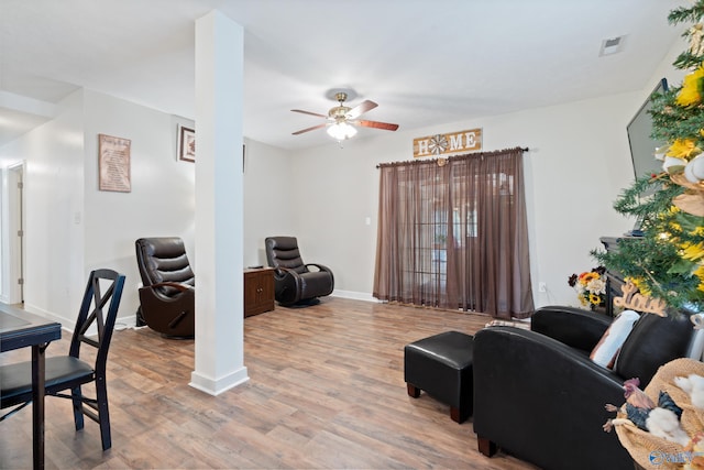 living room featuring ceiling fan and light hardwood / wood-style flooring