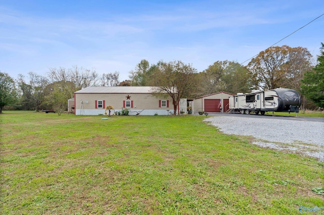 view of front facade with a garage, an outdoor structure, and a front yard