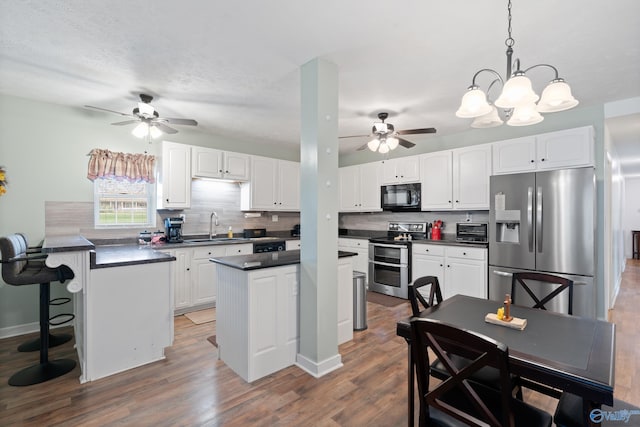 kitchen with white cabinets, pendant lighting, a center island, and stainless steel appliances