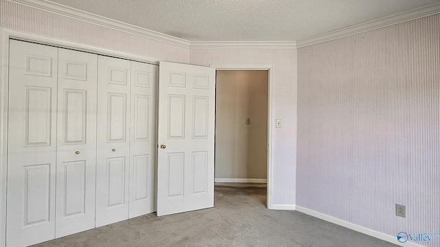 unfurnished bedroom with light carpet, baseboards, ornamental molding, a textured ceiling, and a closet