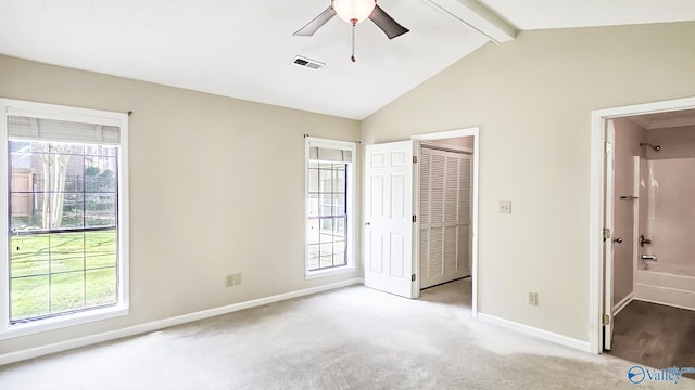 unfurnished bedroom featuring lofted ceiling with beams, light colored carpet, visible vents, baseboards, and a closet