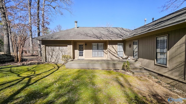 rear view of property featuring fence and a lawn