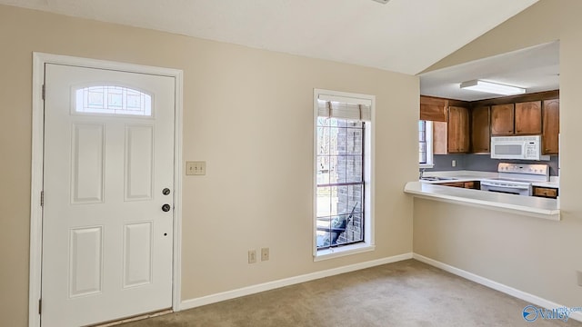 foyer entrance with baseboards, lofted ceiling, and light colored carpet