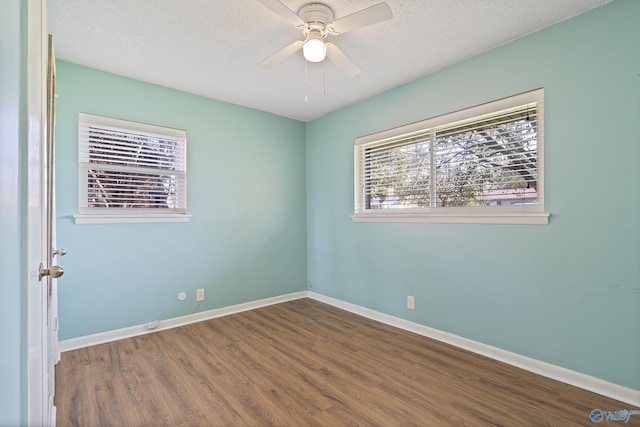 empty room with baseboards, wood finished floors, a textured ceiling, and ceiling fan