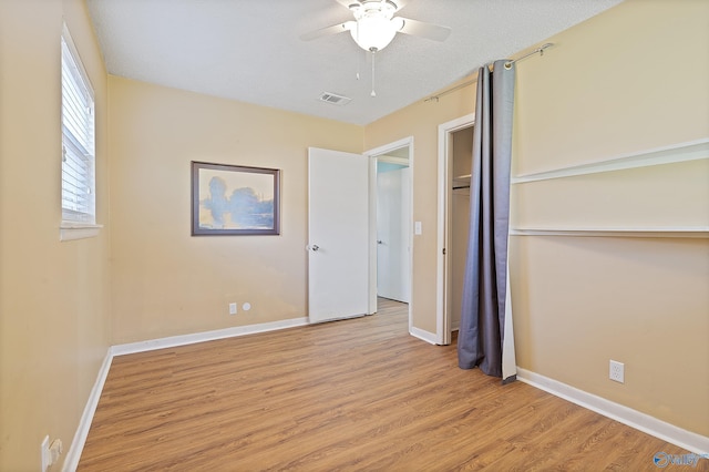 unfurnished bedroom featuring light wood-style flooring, visible vents, baseboards, and ceiling fan