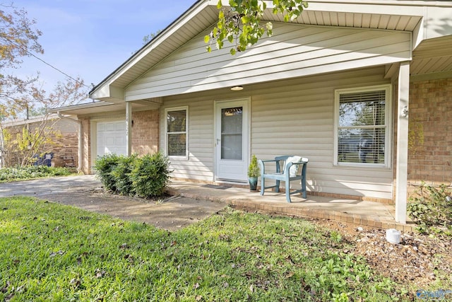 view of front of home featuring covered porch, brick siding, and a garage