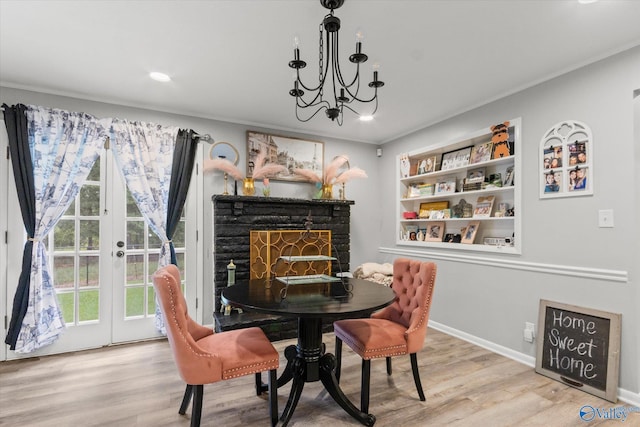 dining area with ornamental molding, a chandelier, and light hardwood / wood-style flooring