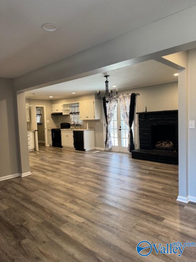 unfurnished living room with french doors, dark hardwood / wood-style floors, and a notable chandelier