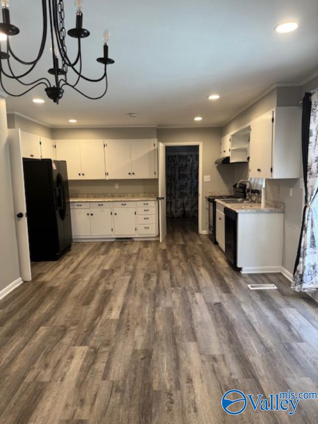 kitchen with dark hardwood / wood-style flooring, white cabinets, and black appliances