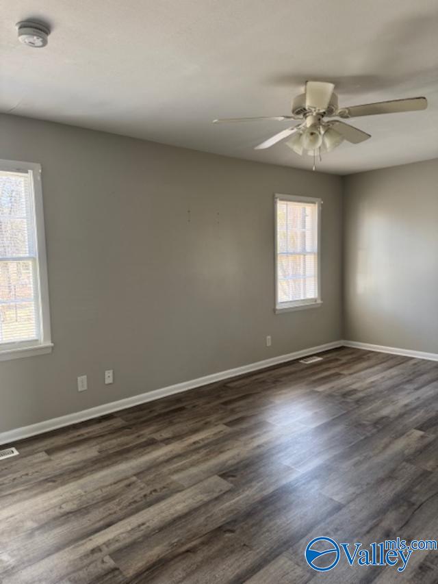 unfurnished room with ceiling fan and dark hardwood / wood-style floors