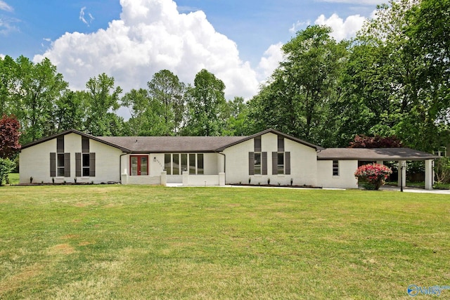 back of property featuring a yard, a sunroom, and a carport