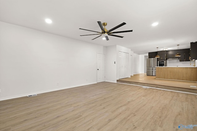 unfurnished living room with visible vents, baseboards, recessed lighting, a ceiling fan, and light wood finished floors