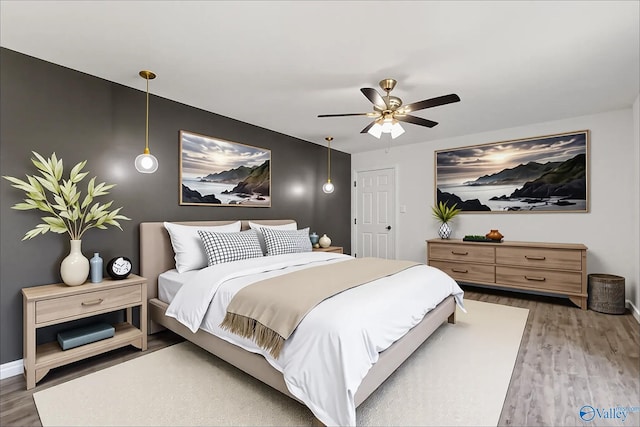 bedroom featuring baseboards, ceiling fan, and wood finished floors