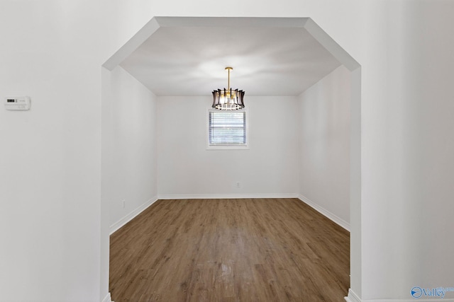 unfurnished dining area with baseboards and wood finished floors