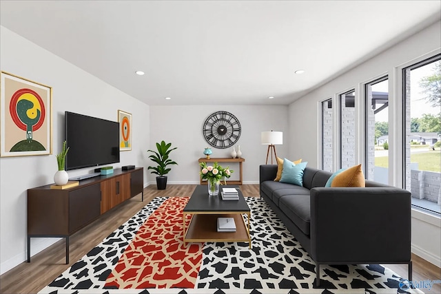living room featuring recessed lighting, baseboards, and wood finished floors