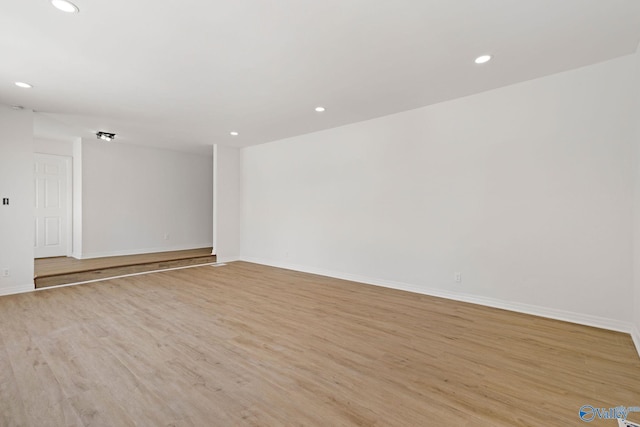 spare room featuring recessed lighting, baseboards, and light wood-type flooring