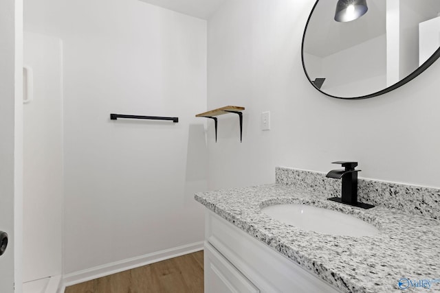 bathroom with vanity, baseboards, and wood finished floors