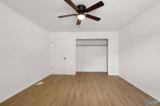 unfurnished bedroom featuring baseboards, a closet, light wood-type flooring, and visible vents