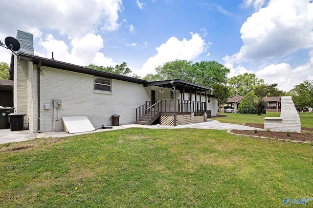 rear view of property with a yard and brick siding