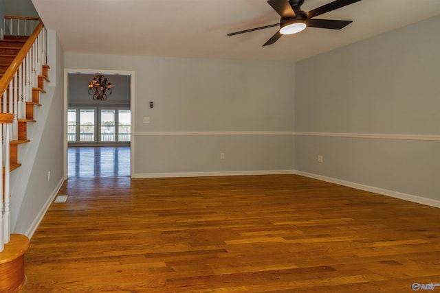 1204 Sibert Dr, Glencoe, AL 35905 - spare room featuring stairs, a chandelier, ceiling fan, wood finished floors, and baseboards