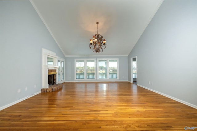 1204 Sibert Dr, Glencoe, AL 35905 - unfurnished living room featuring high vaulted ceiling, plenty of natural light, a chandelier, wood finished floors, and baseboards