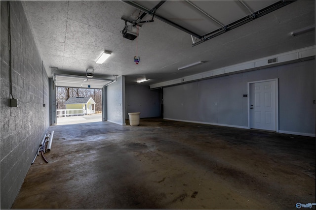 1204 Sibert Dr, Glencoe, AL 35905 - garage featuring a garage door opener and concrete block wall
