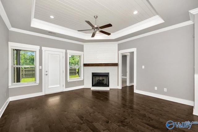 unfurnished living room with dark hardwood / wood-style flooring, a tray ceiling, ceiling fan, and crown molding