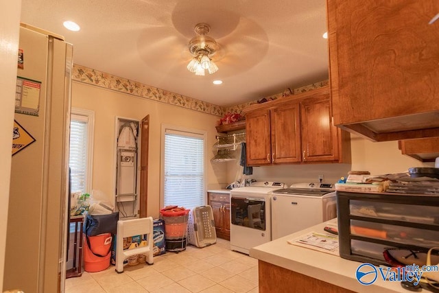 kitchen featuring light tile patterned floors, washer and dryer, and ceiling fan