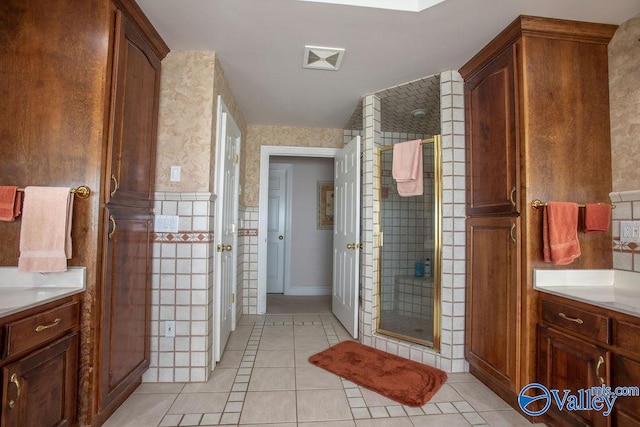 bathroom with vanity, an enclosed shower, and tile patterned floors