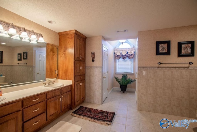 bathroom featuring vanity, tile patterned flooring, and a textured ceiling