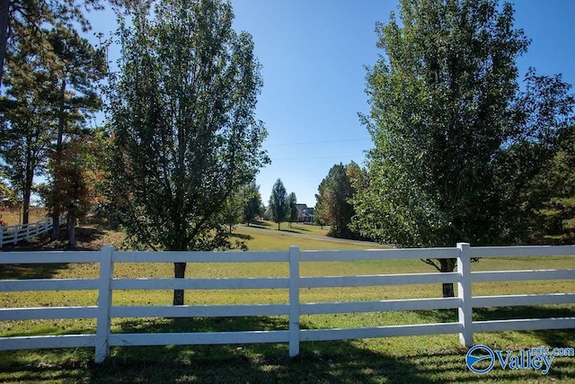 view of gate with a rural view and a yard