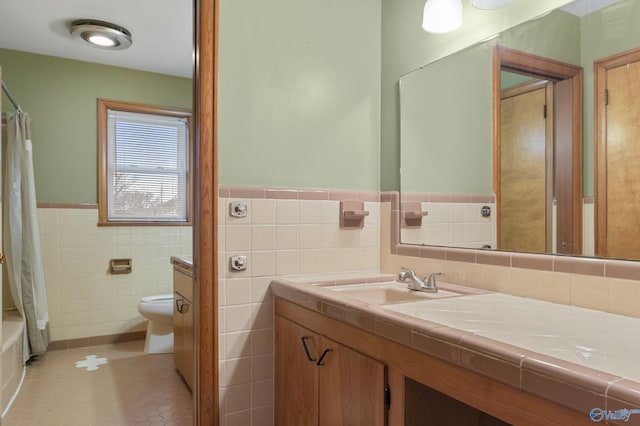 full bathroom with toilet, shower / tub combo, tile walls, vanity, and tile patterned flooring