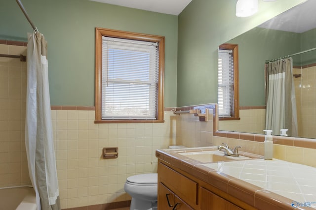 full bathroom with vanity, tile walls, shower / bathtub combination with curtain, and toilet