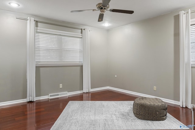 unfurnished room with ceiling fan and dark hardwood / wood-style flooring