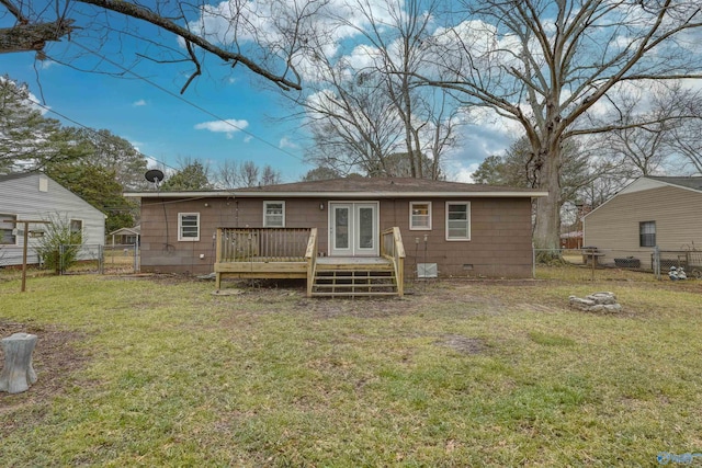 back of house with a lawn, a wooden deck, and french doors