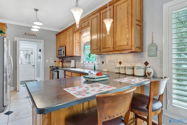 178 Ridgewood Cir, Cherokee Ridge, AL 35175 - kitchen with stainless steel appliances, a sink, decorative backsplash, a kitchen breakfast bar, and pendant lighting