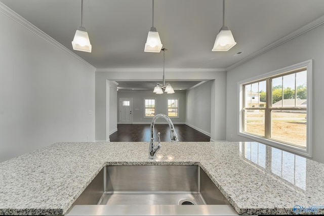 kitchen featuring a chandelier, hanging light fixtures, sink, ornamental molding, and light stone counters