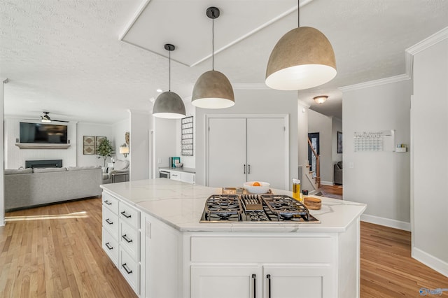 kitchen with a fireplace, light wood finished floors, black gas cooktop, white cabinetry, and ceiling fan