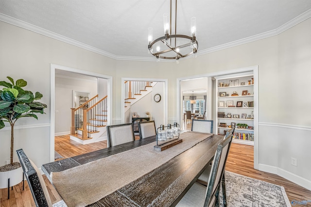 dining space featuring baseboards, stairway, wood finished floors, an inviting chandelier, and crown molding