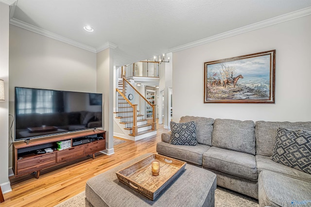 living area with crown molding, stairway, and wood finished floors