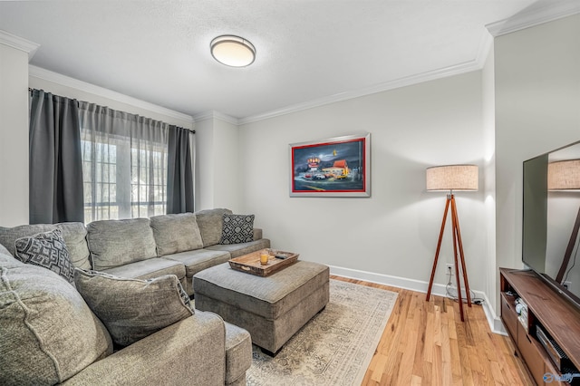 living area with light wood-type flooring, baseboards, and ornamental molding