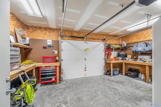 garage with a garage door opener and a workshop area