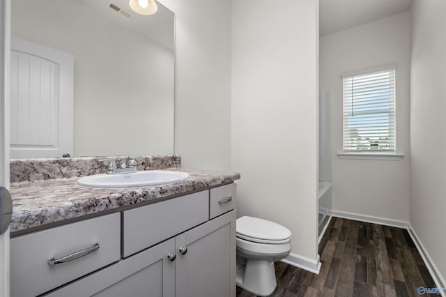 bathroom featuring vanity, wood-type flooring, and toilet