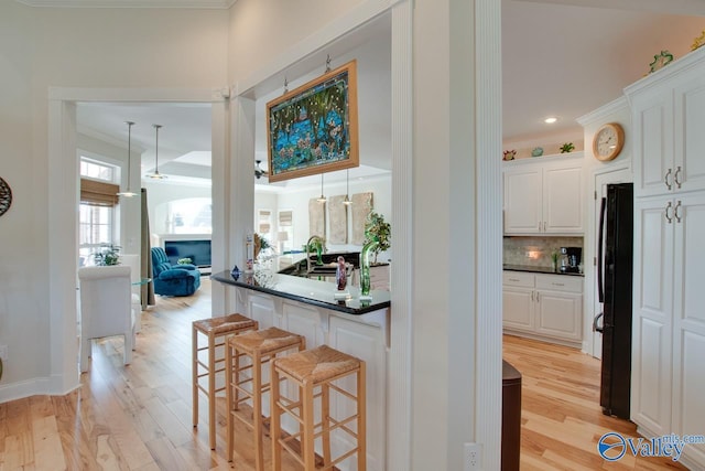 227 Lee Bowden Dr, Huntsville, AL 35806 - bar area with crown molding, freestanding refrigerator, light wood-style floors, backsplash, and recessed lighting