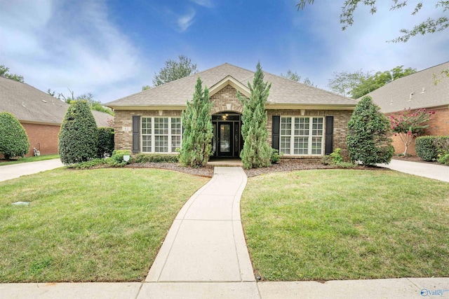 single story home featuring brick siding, a front yard, and a shingled roof