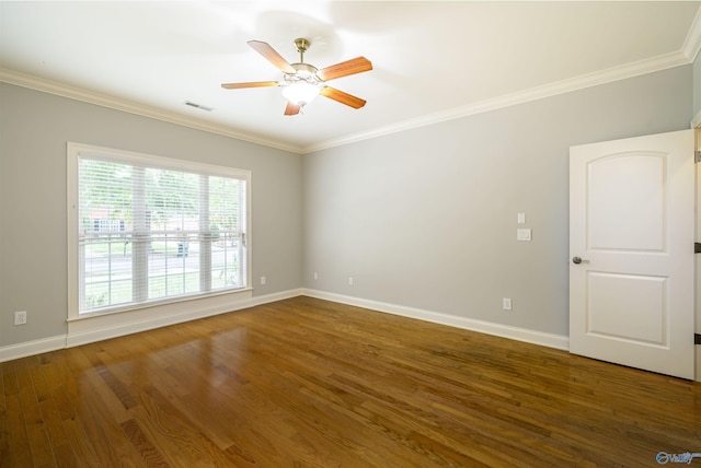 spare room with ornamental molding, wood finished floors, visible vents, and baseboards