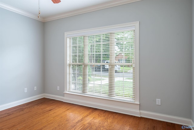 unfurnished room featuring baseboards, plenty of natural light, and wood finished floors