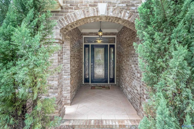 doorway to property featuring brick siding