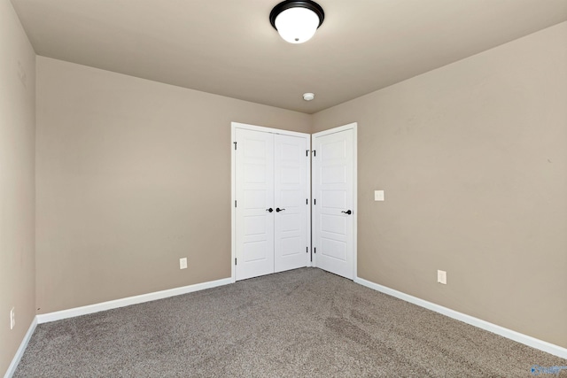 unfurnished bedroom featuring carpet, a closet, and baseboards